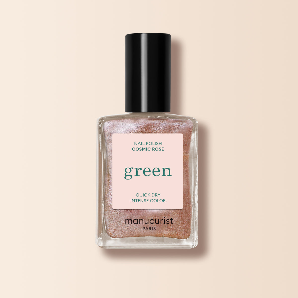 A bottle of Manucurist Cosmic Rose nail polish, an iridescent pink shade from the Green™ range with a black cap, is photographed against a light beige background.