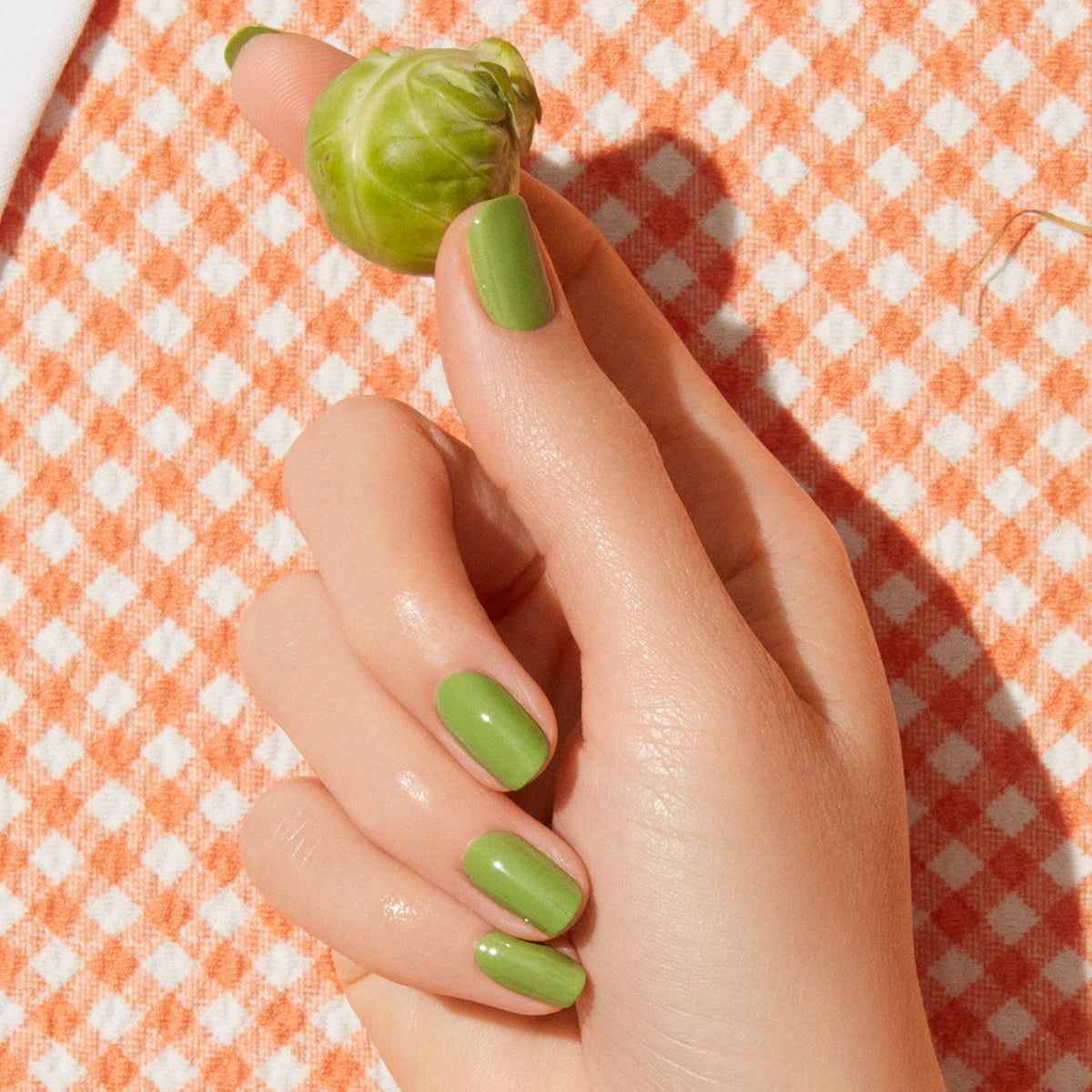 A hand with neatly manicured nails painted in Manucurist&