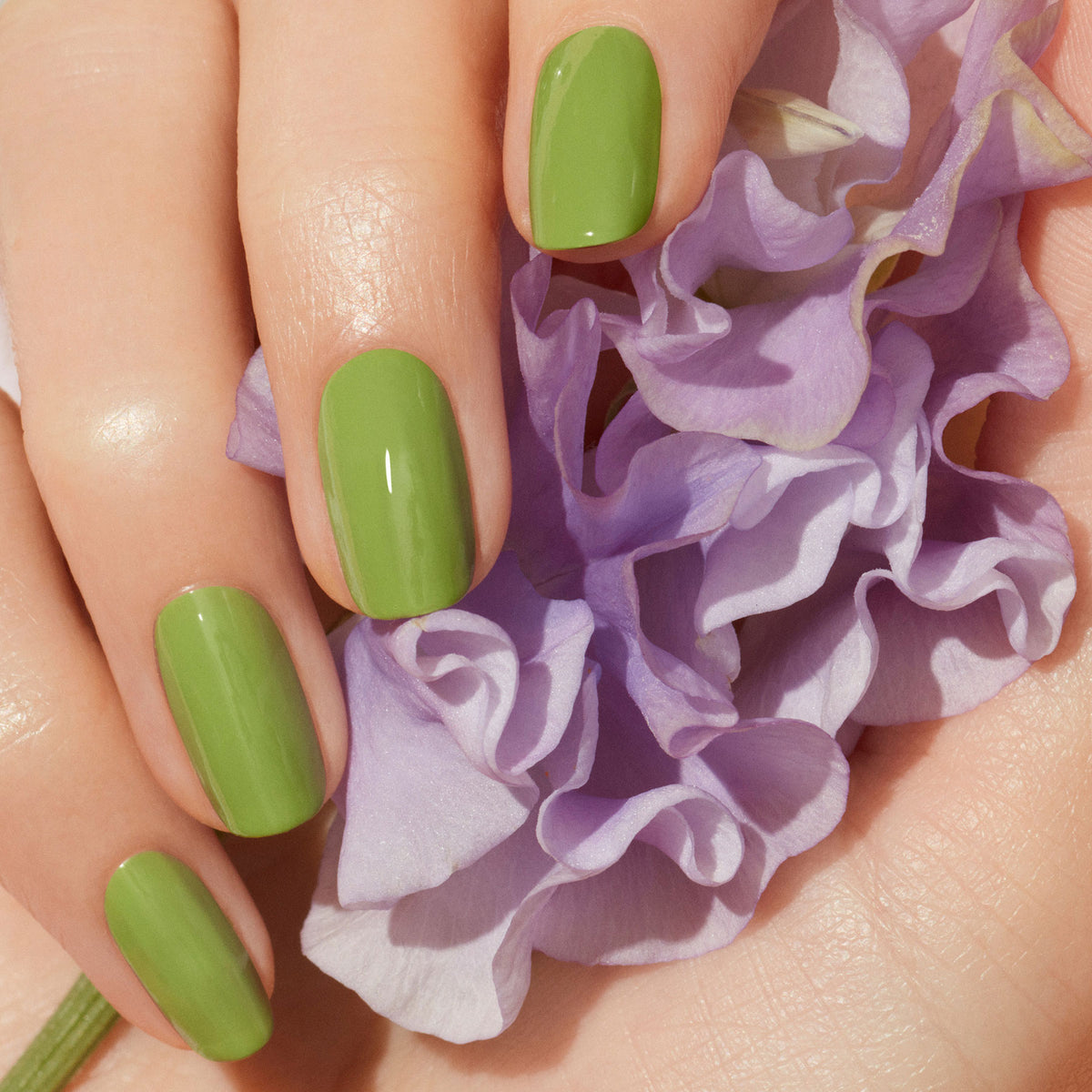 A hand with short, neatly shaped nails painted in Manucurist&