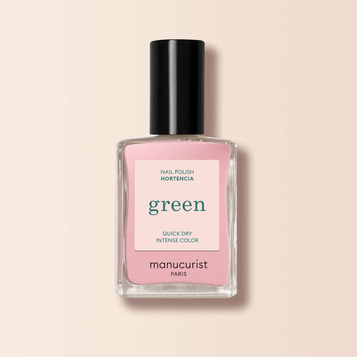 A bottle of Manucurist Hortencia natural nail polish, a pale pink shade, shown with a black cap and square glass bottle, set against a soft beige background.