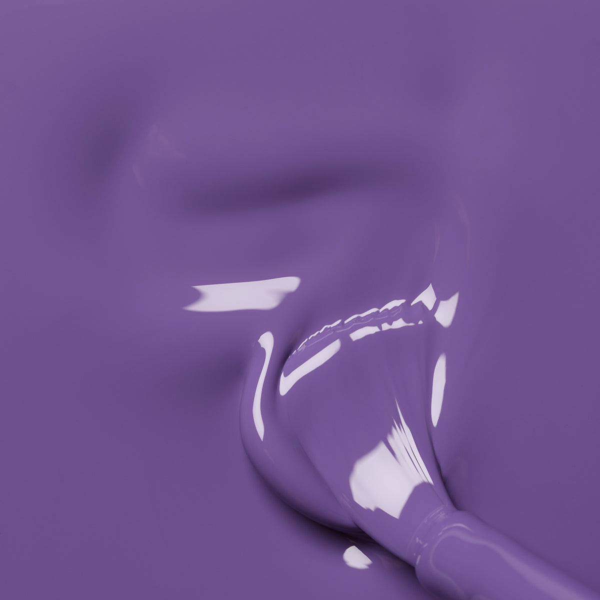A close-up of a paintbrush partially dipped in Manucurist&