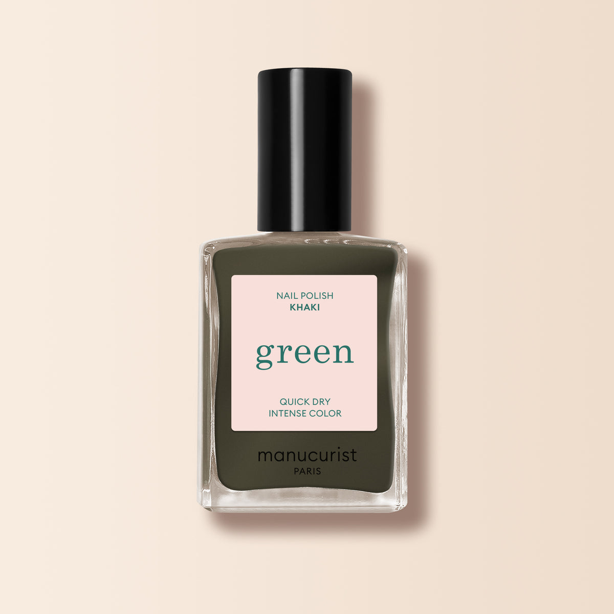 A Khaki shade nail polish by Manucurist, from the Green™ range, featuring a black cap and quick dry intense color, is displayed against a light beige background.