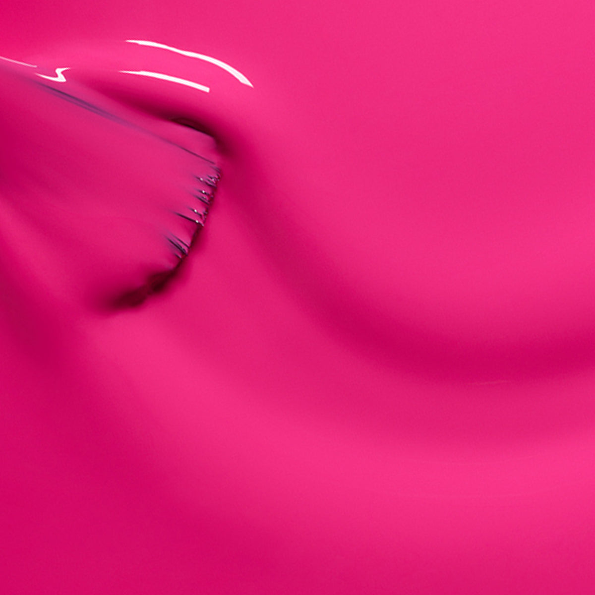 A close-up of Manucurist’s Pétula, a bright pink gel polish, being smoothly applied with a brush for glossy curves—the perfect summer nail look.