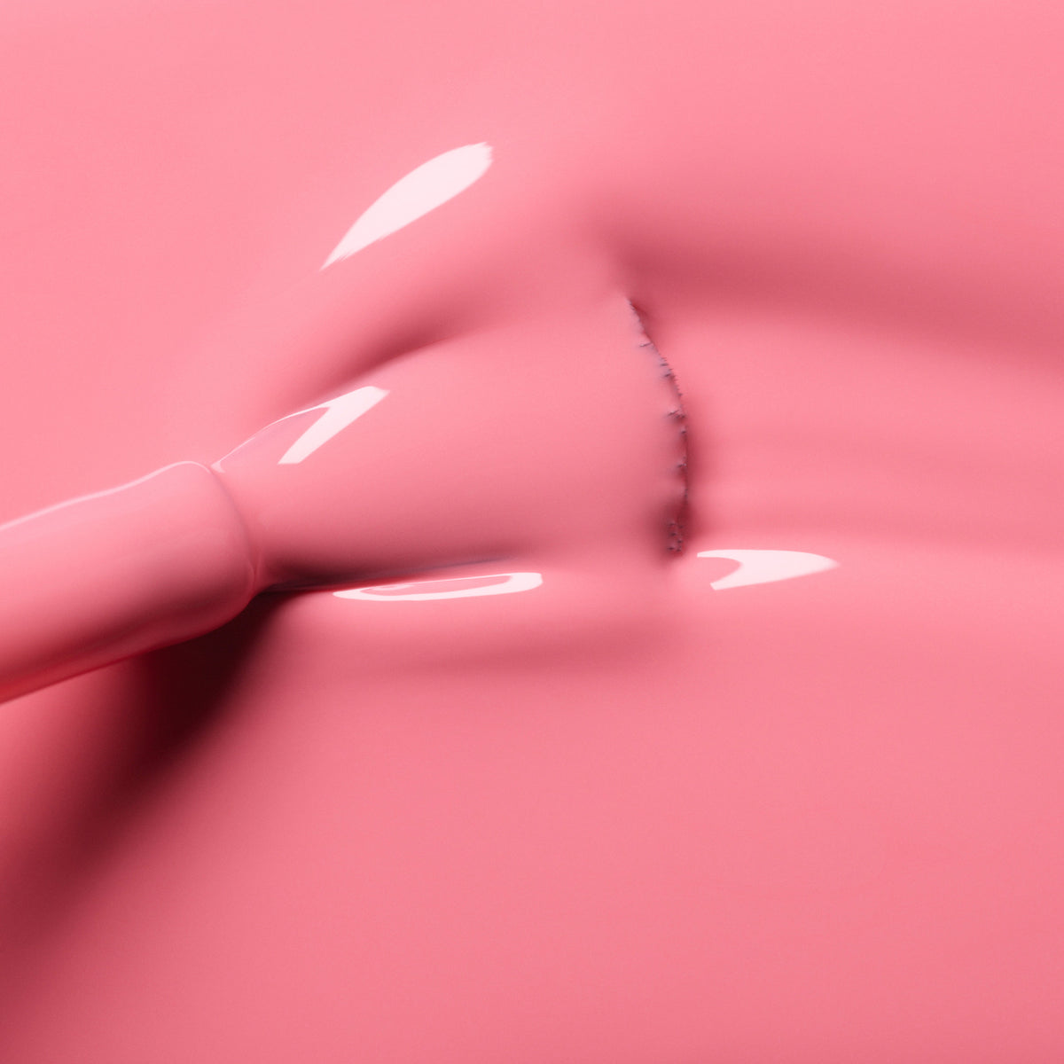 A close-up of the Manucurist Pink Paradise brush applying glossy, candy pink gel polish, with smooth highlights and visible bristles creating a streak in the wet finish.