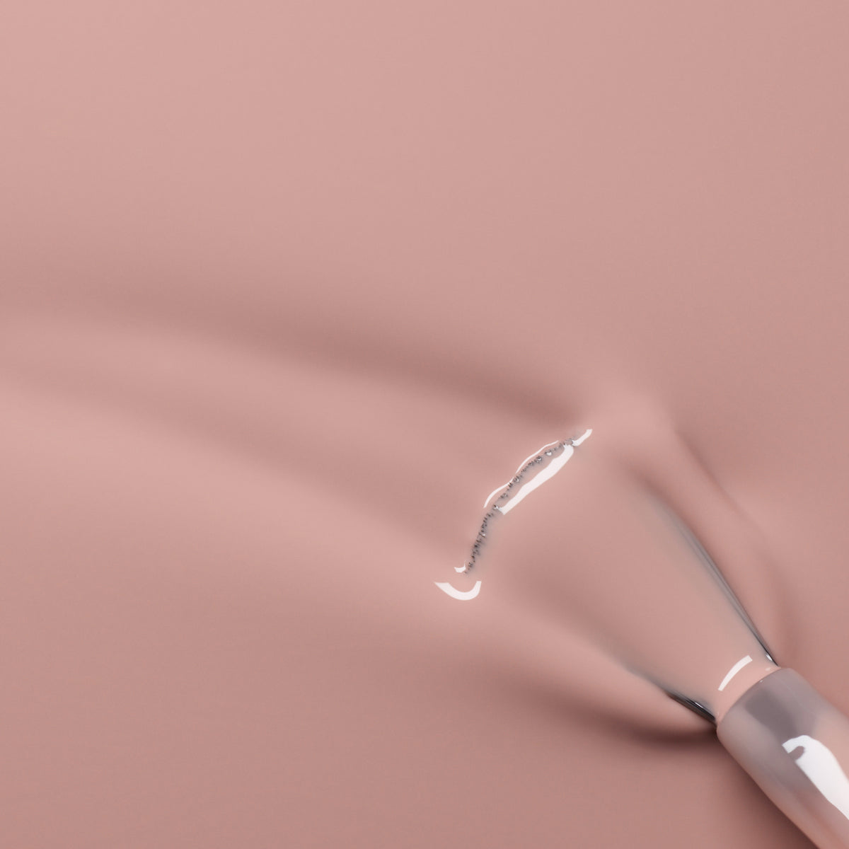 A close-up of a Manucurist Shell Beige brush applying delicate pinkish beige gel polish in smooth strokes over a matching pink surface.