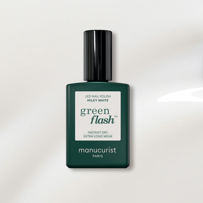 A bottle of Manucurist-test Milky white OLD LED gel nail polish, with a dark green label and black cap, is displayed on a light background. This polish delivers a salon-quality finish that’s easy to remove at home.