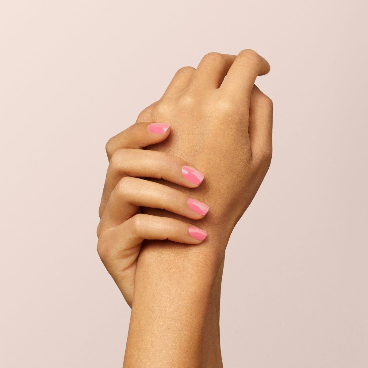 Two hands with neatly manicured nails, painted in Manucurist&